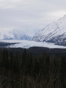 Glacer at the base of two mountains covered with snow