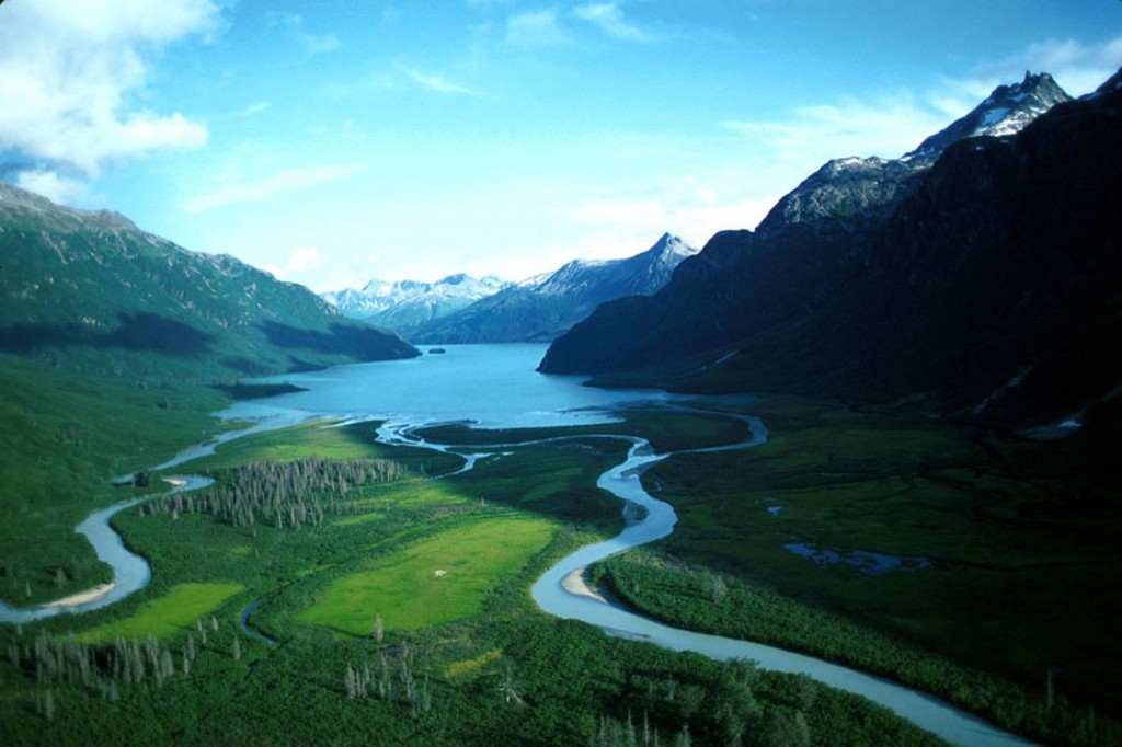 a large lake with rivers running out of it tucked between tall peaks all around