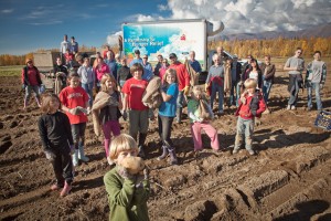 A group of kids in the potato fields smiling for the camera