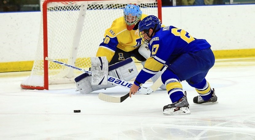 university of alaska nanook male hockey player goes head to head for the puck against a rival team's goalie in order to score a goal